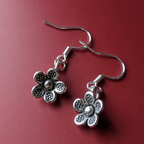 E181 Minka Flower Earrings. Flower shaped fine silver dangle earrings. Complete with tiny oxidised flower stamping on each petal. Fair Trade, handmade
