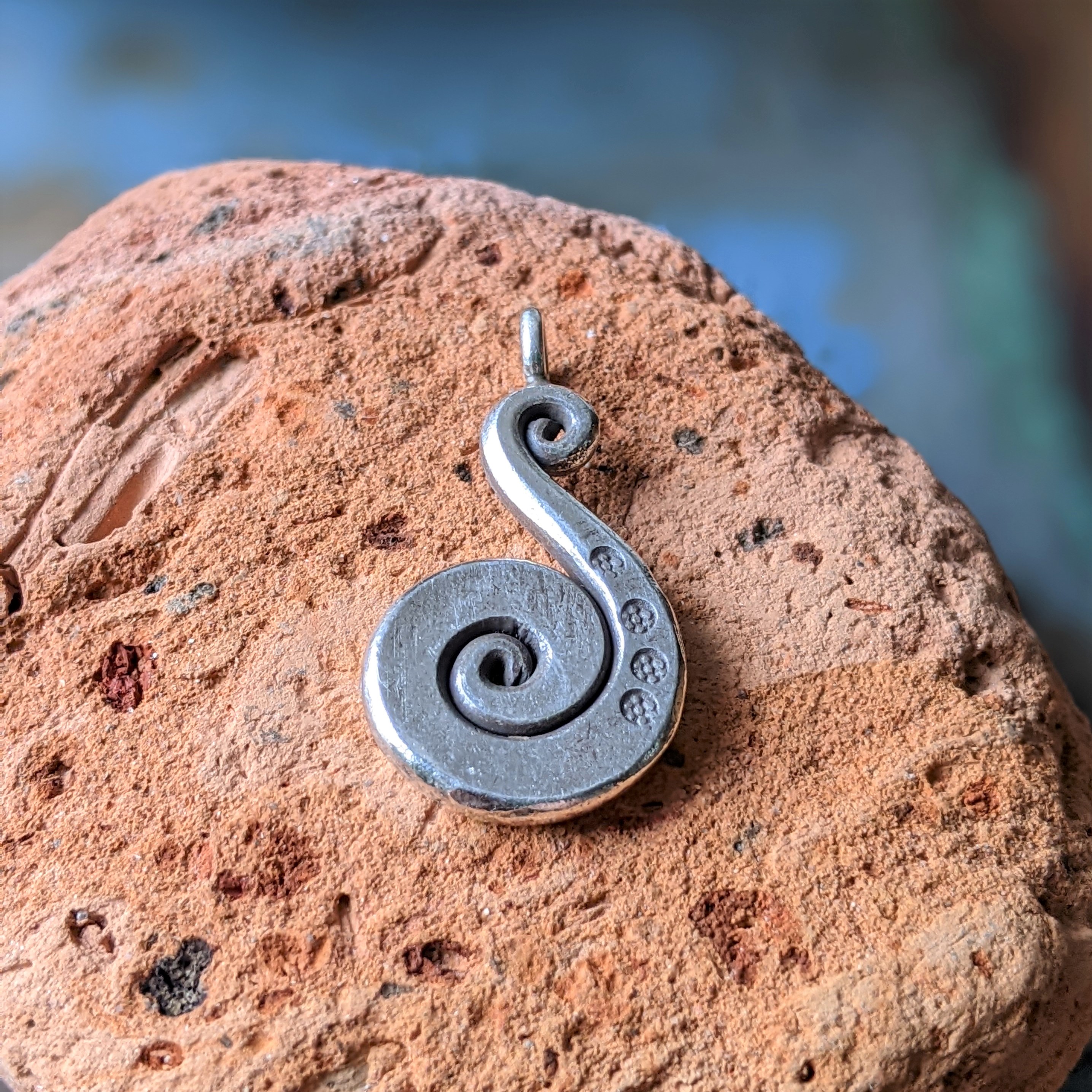 P211 Farah Spiral Pendant. Handmade flattened silver swirl pendant with 4 delicate and tiny oxidised flower stamps.