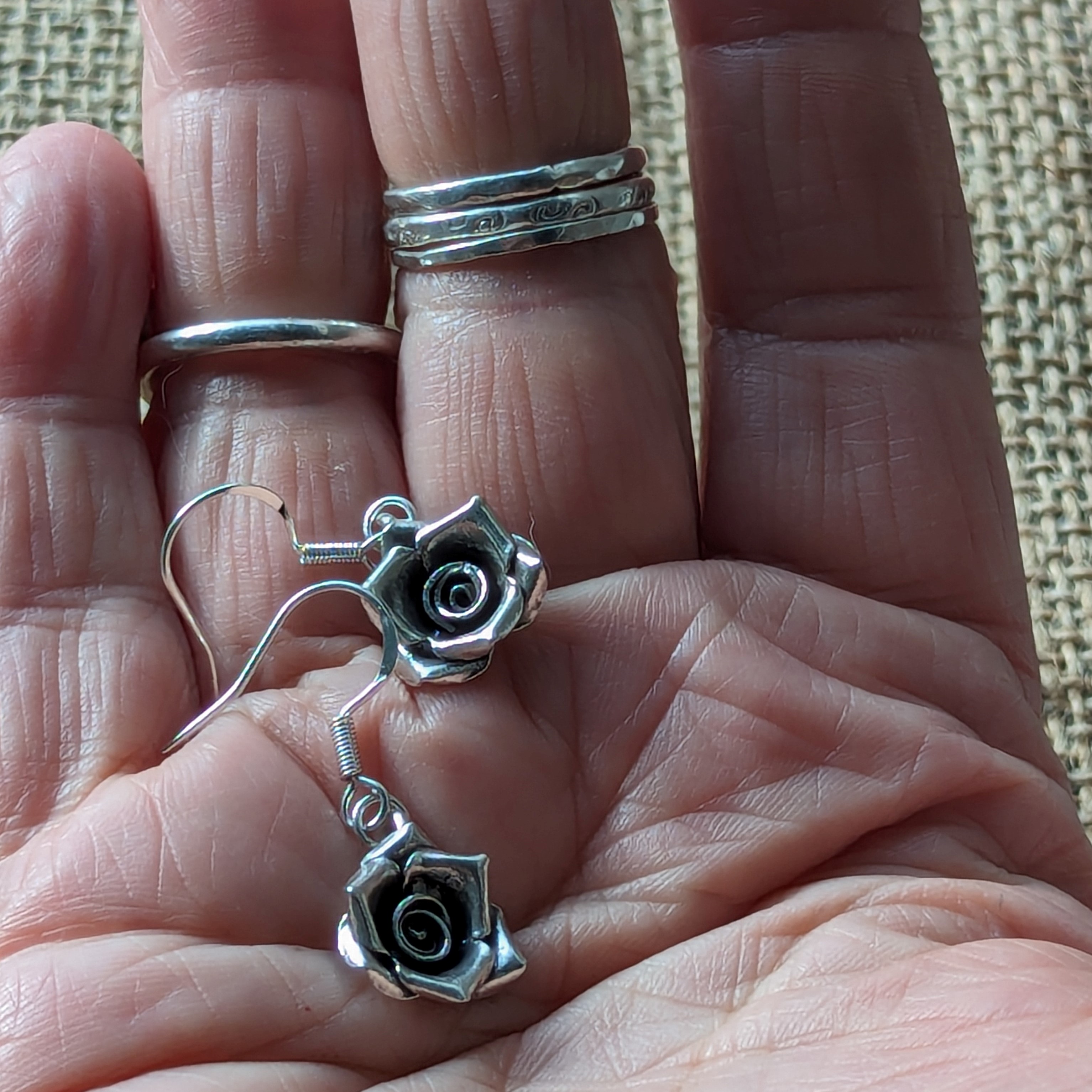 E193 Talia Rose Earrings. Rose shaped dangle drop earrings, created from recycled fine silver. Ethically created and Fair Trade.