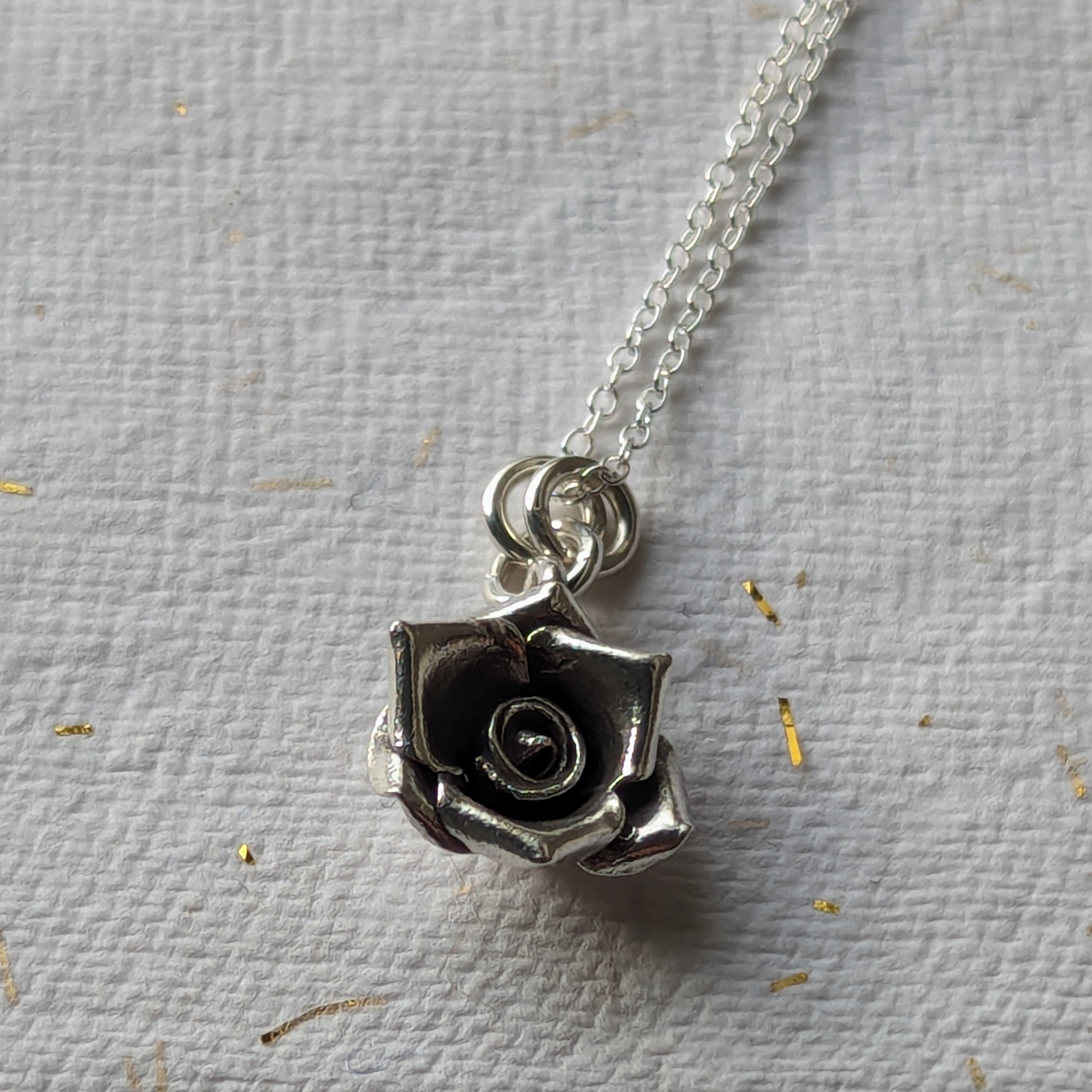 N111 Talia Rose Pendant Necklace. Rose shaped pendant hanging on a sterling silver chain, created from recycled fine silver. Ethically created and Fair Trade.