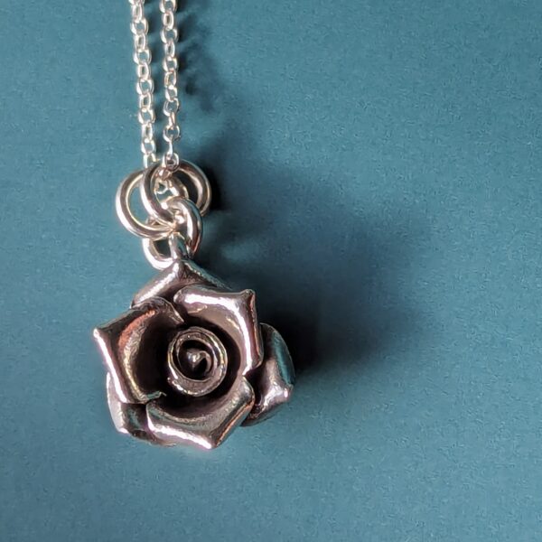 N111 Talia Rose Pendant Necklace. Rose shaped pendant hanging on a sterling silver chain, created from recycled fine silver. Ethically created and Fair Trade.