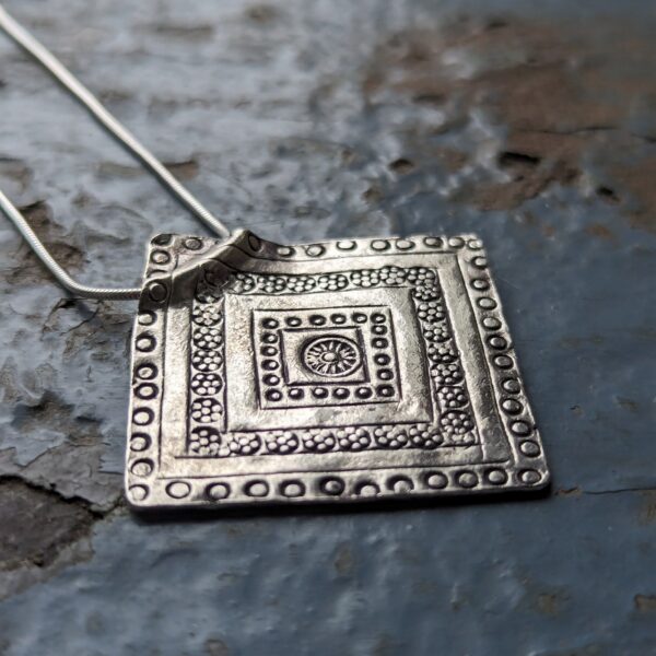 HL743 Concordia Pendant Necklace. Fine silver diamond shaped pendant with geometric oxidised stamped detailing. Hung from a silver snake chain. Fair Trade, ethically made. Unique jewellery