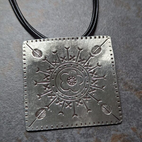 HL747 Ostara Necklace. Fair Trade, handmade from recycled silver this pendant can be strung on either a tough nylon cord or a snake chain. The square pendant has oxidised stamped detailing of flowers, leaves and geometric patterns.