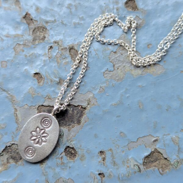 P036 Ethel Pendant. Oval shaped disc pendant with oxidised stamped detailing. Ethically handcrafted from recycled fine silver. A choice of necklaces are available