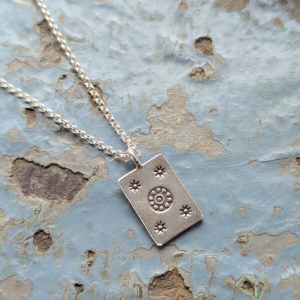 P044 Josie Pendant. Rectangular pendant with oxidised star and flower stamping. Ethically handmade from recycled fine silver. Fair Trade. A choice of necklaces is available.