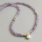 N125 Doris Gem and Charm Necklace - Amethyst. Faceted gemstone beads with Fair Trade silver beads and a central silver charm detail. Clasp sterling silver.