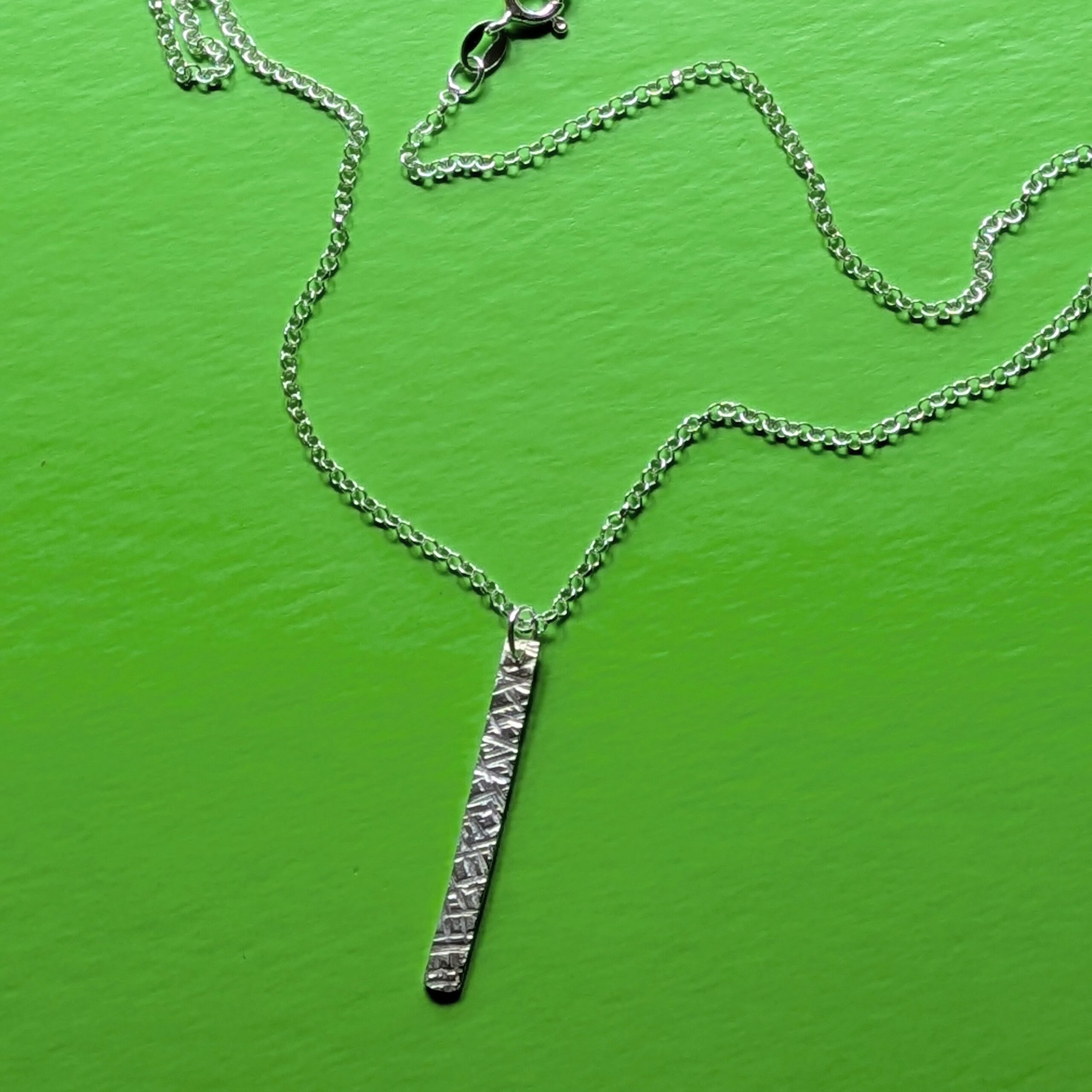 N130 Bronte Necklace. Elegant pendant drop necklace with a textured surface to play with the light whilst worn. Hand made in Cheshire, UK from recycled silver.