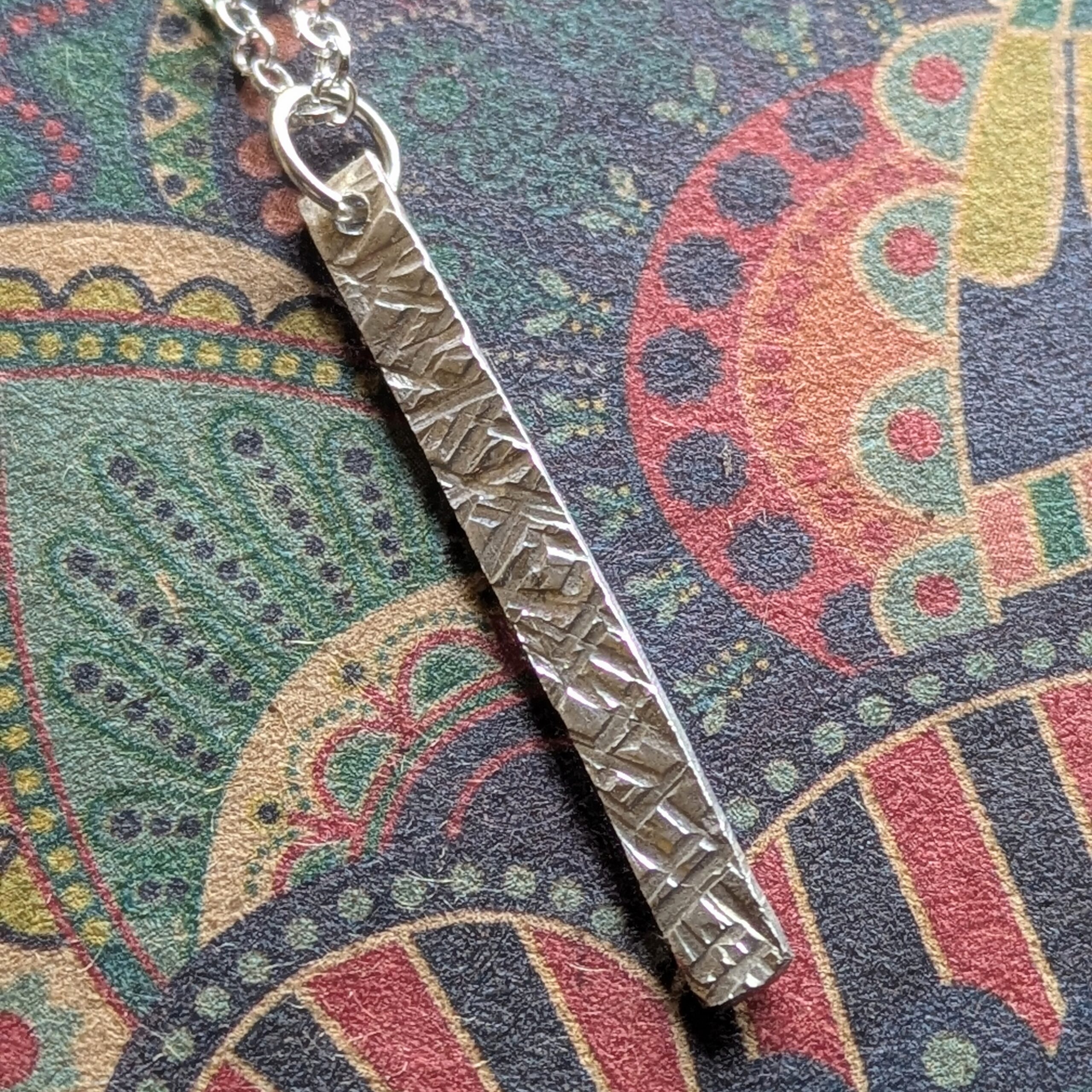 N130 Bronte Necklace. Elegant pendant drop necklace with a textured surface to play with the light whilst worn. Hand made in Cheshire, UK from recycled silver.