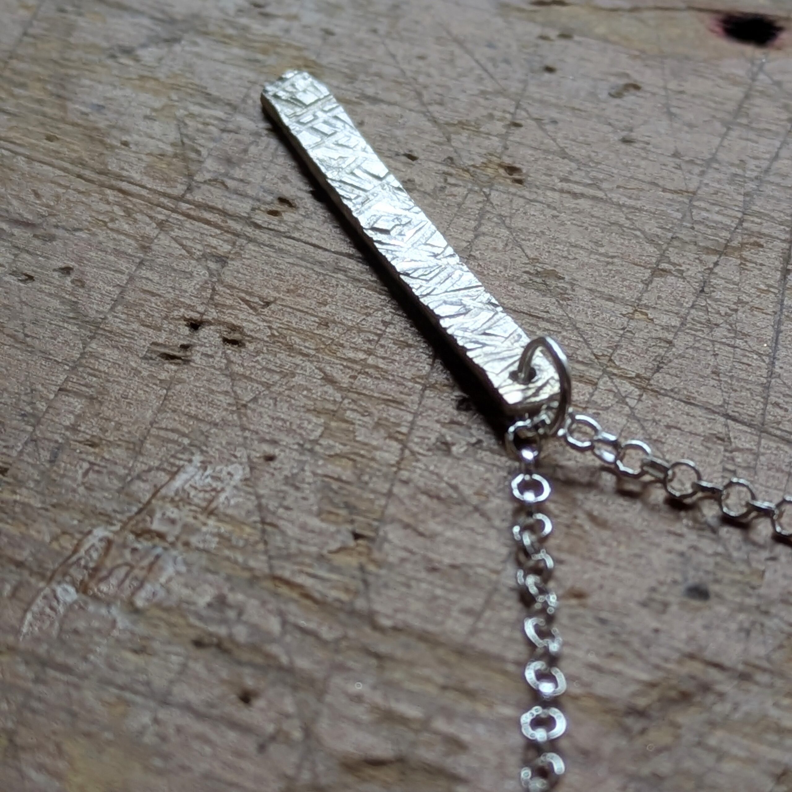 N130 Bronte Necklace. Elegant pendant drop necklace with a textured surface to play with the light whilst worn. Hand made in Cheshire, UK from recycled silver.