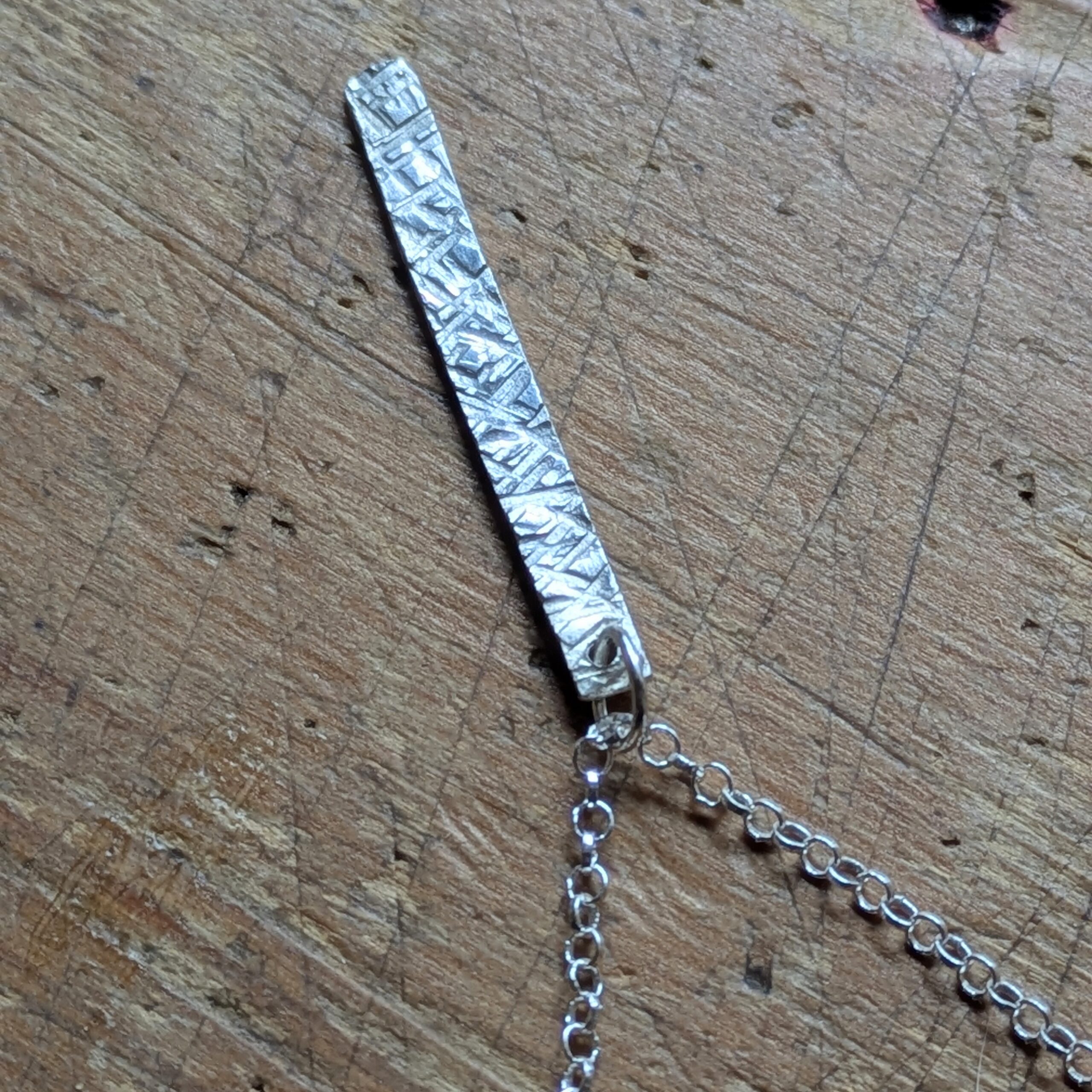 N130 Bronte Necklace. Elegant pendant drop necklace with a textured surface to play with the light whilst worn. Hand made in Cheshire, UK from recycled silver.