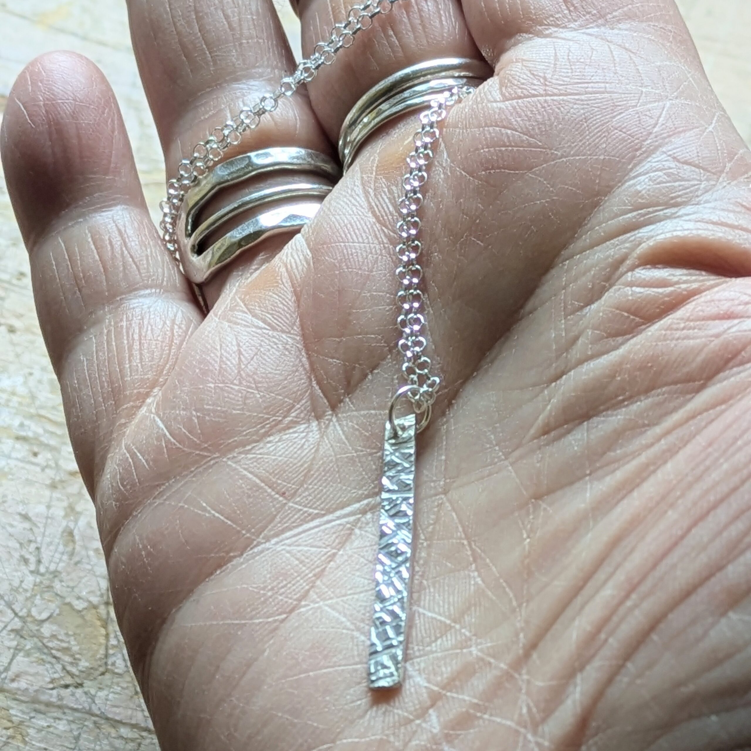 N130 Bronte Necklace. Elegant pendant drop necklace with a textured surface to play with the light whilst worn. Hand made in Cheshire, UK from recycled silver.