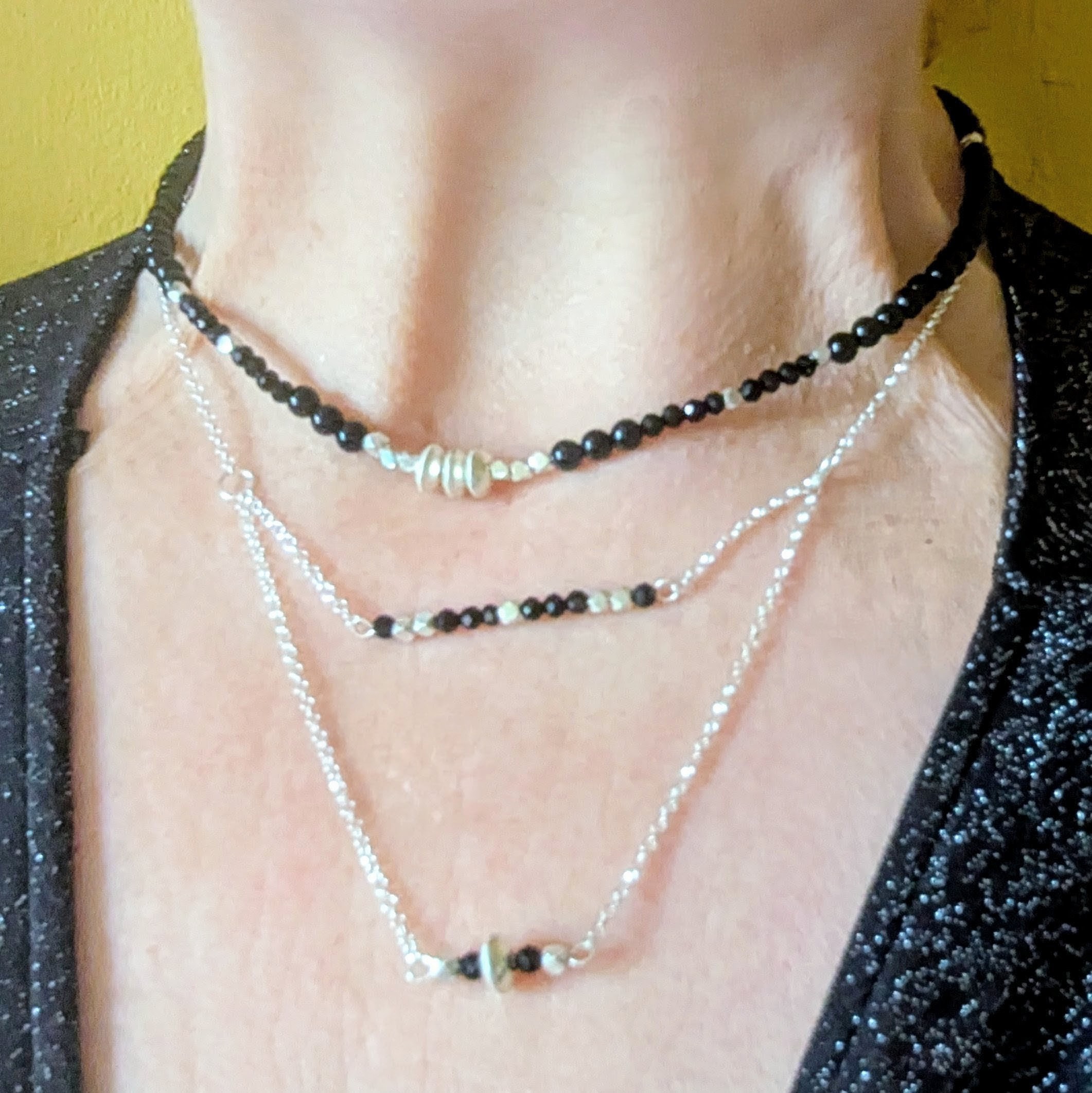 N131 Noctis Necklace and N132 Renfri Necklaces, worn layered on model - Black onyx and Fair Trade recycled silver beaded necklace. Modern Gothic aesthetic.